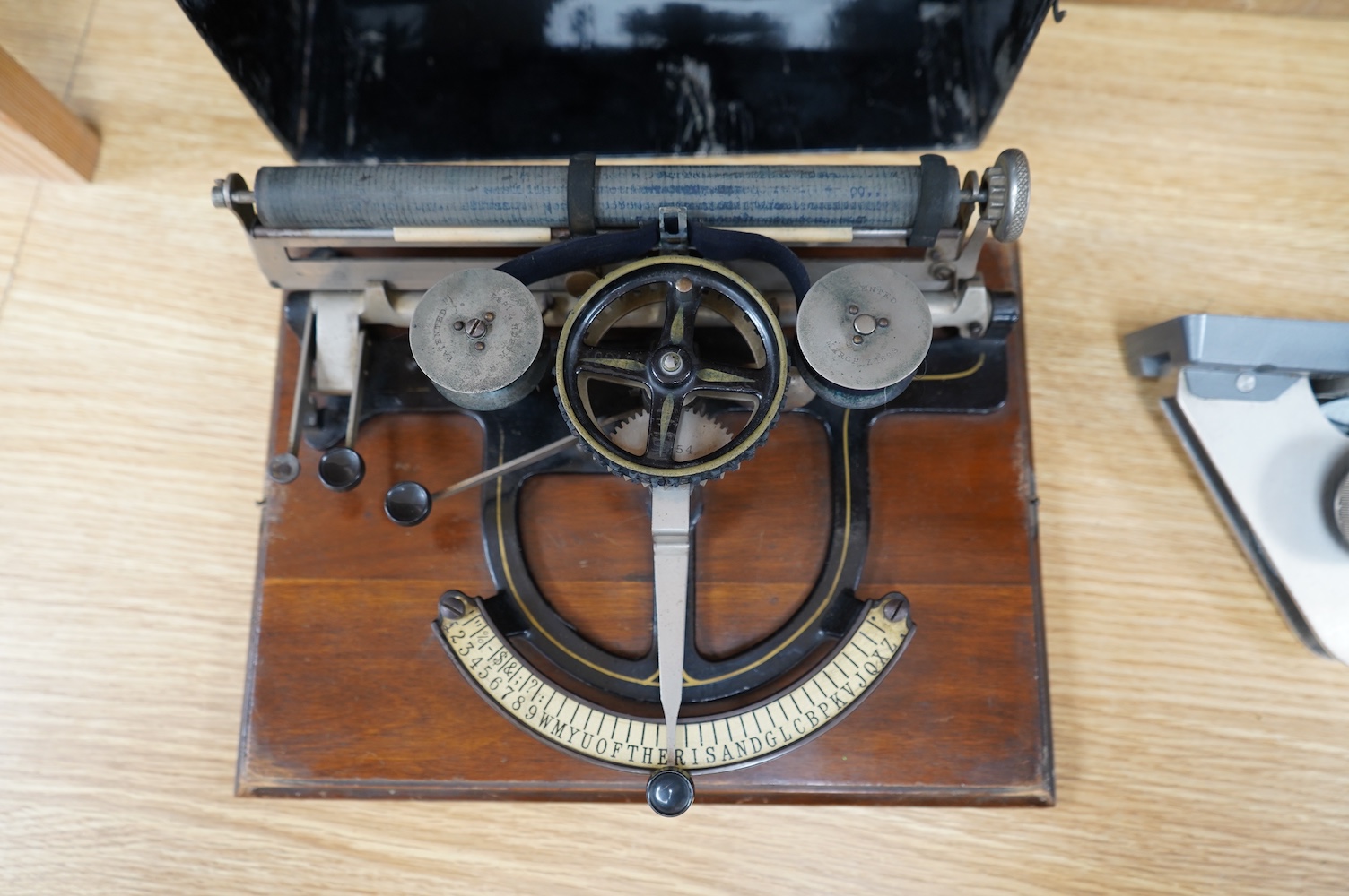 A Peoples Champion Indexing Typewriter, circa 1893, by the Garvin Machine Co., New York, on a mahogany plinth, with black tin cover, inscribed ‘’PEX’’ CHAMPION, width 28cm; a Bar-Let vintage typewriter, cased; an Underwo